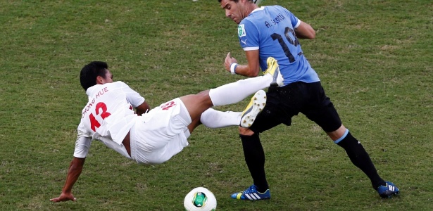 23.jun.2013 - Andrés Scotti comete falta em Steevy Chong Hue durante a vitória por 8 a 0 do Uruguai sobre o Taiti na Arena Pernambuco pela Copa das Confederações