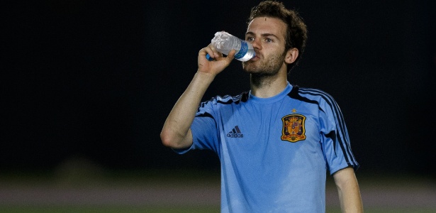Suado, Juan Mata bebe água em descanso no treino da Espanha