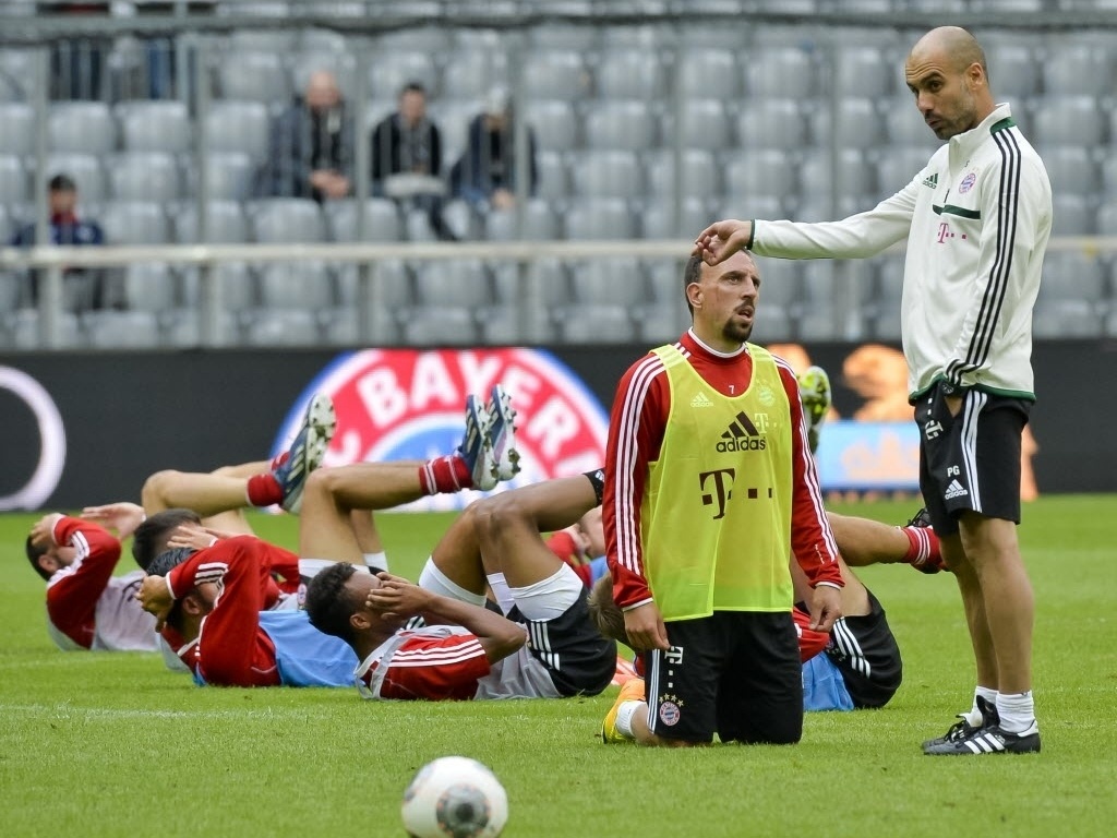 26.06.2013 - Guardiola (em pé) tenta implantar sua filosofia aos jogadores do Bayern de Munique - GUENTER SCHIFFMANN / AFP