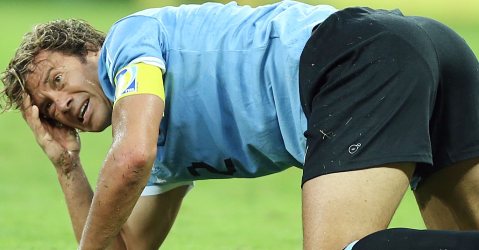 26.jun.2013 - Lugano fica caído no gramado em lance da partida entre Brasil e Uruguai no Mineirão