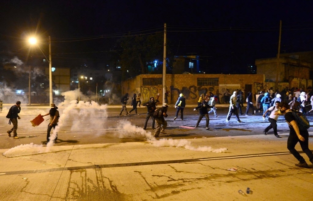 26.jun.2013 - Manifestantes correm de bombas de gás lacrimogêneo lançadas pela polícia em confronto nos arredores do Mineirão