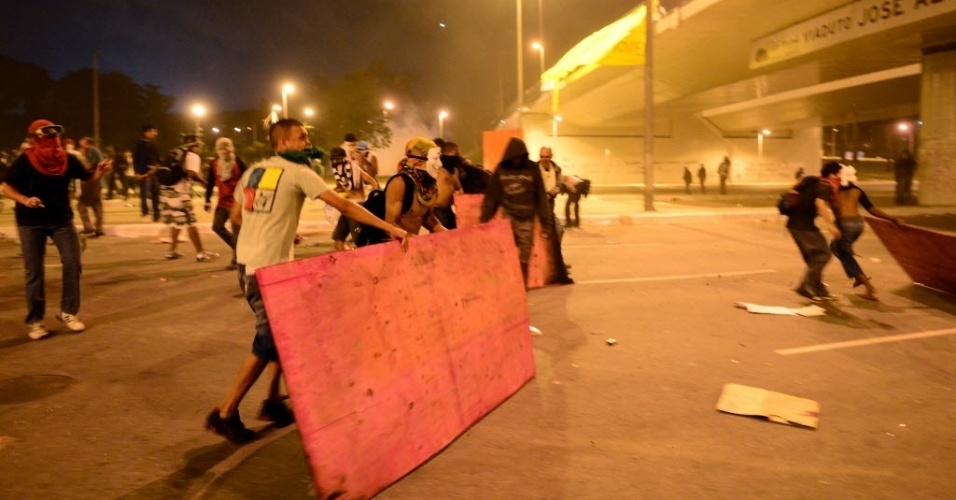 26.jun.2013 - Manifestantes pegam pedaços de madeira para se proteger de balas de borracha da polícia em BH