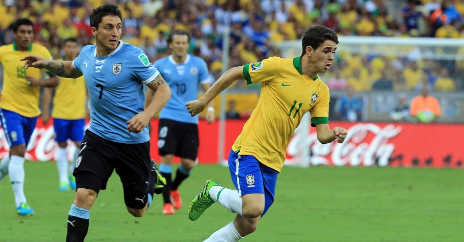 26.jun.2013 - Observado pelos uruguaios, Oscar parte com a bola dominada em lance da partida no Mineirão; Brasil venceu por 2 a 1 e se classificou para a final da Copa das Confederações