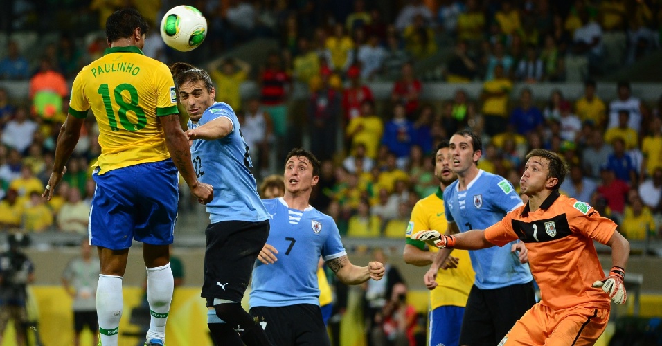 26.jun.2013 - Paulinho sobe mais do que a zaga uruguaia e, de cabeça, marca o gol da vitória brasileira no Mineirão