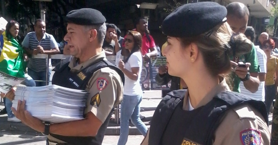 26.jun.2013 - Policiais entregam panfletos pedindo paz aos manifestantes durante protesto na Praça Sete de Setembro, em Belo Horizonte. O panfleto ainda tem o mapa dos bloqueios ao Mineirão