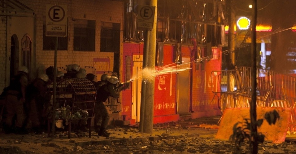 26.jun.2013 - Policial atira bala de borracha contra manifestantes em confronto nos arredores do Mineirão