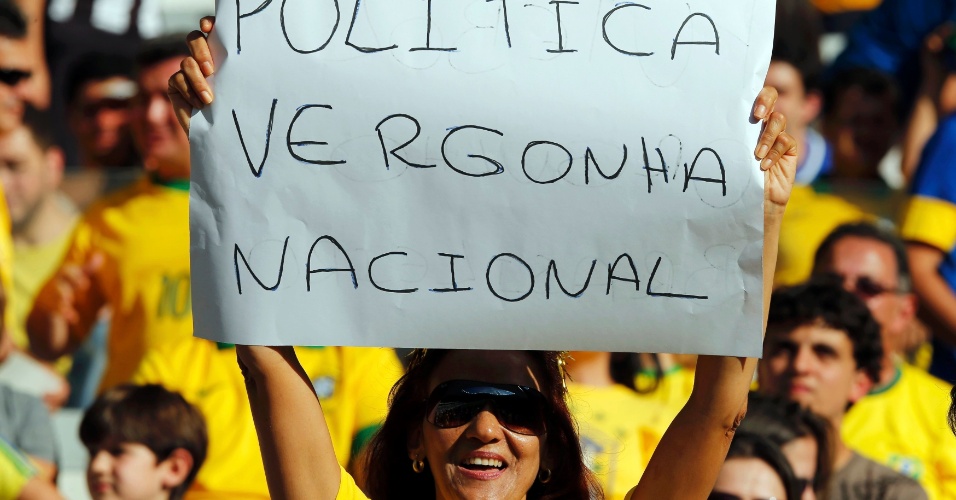 26.jun.2013 - Torcedora carrega cartaz de protesto dentro do Mineirão enquanto aguarda o início da partida entre Brasil e Uruguai
