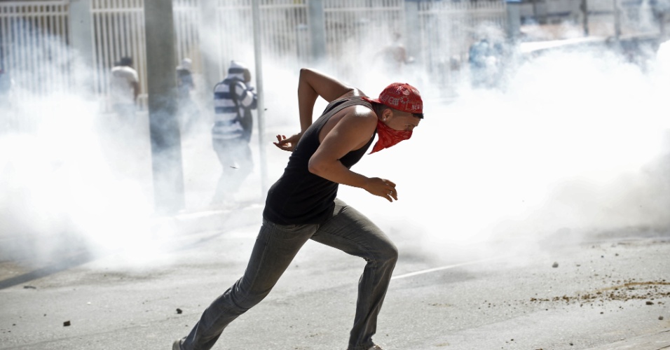 27.jun.2013 - Após um início pacífico de protesto, alguns manifestantes que seguiam rumo ao Castelão começaram a atirar pedras e bombas em direção aos policiais; os oficiais responderam com bombas de gás e de efeito moral