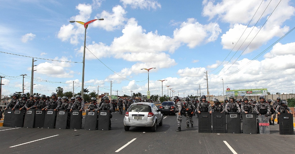 27.jun.2013 - Barreira policial formada no acesso ao Castelão abre espaço para a passagem de carro