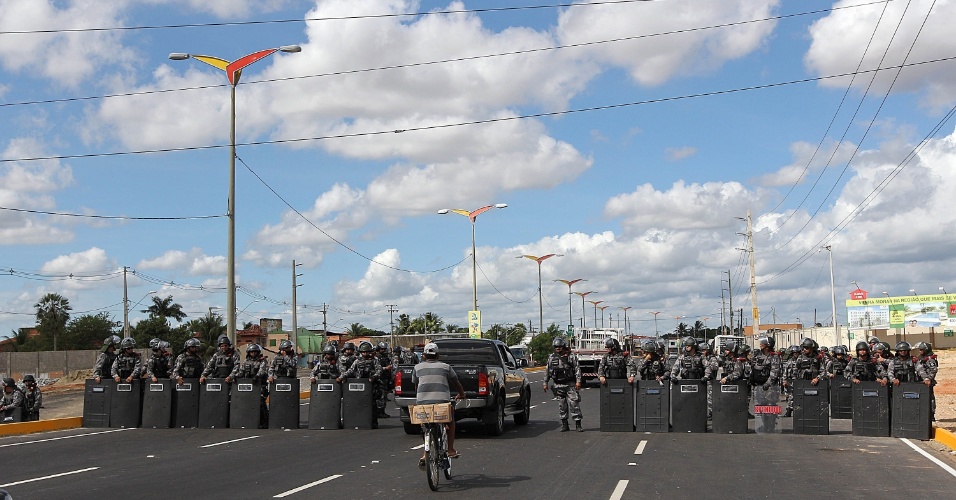 27.jun.2013 - Barreira policial formada no acesso ao Castelão abre espaço para a passagem de carro