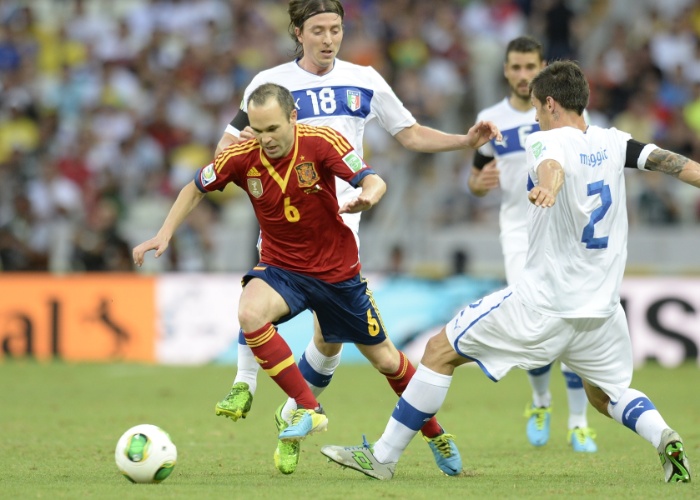 27.jun.2013 - Espanhol Iniesta parte com a bola dominada entre os marcadores da Itália em lance da semifinal da Copa das Confederações