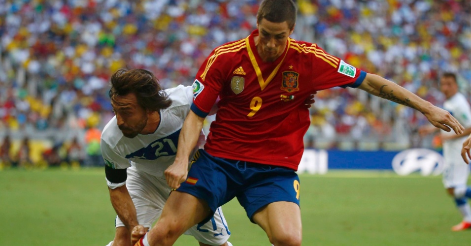 27.jun.2013 - Italiano Pirlo (e) tenta desarmar o espanhol Fernando Torres em lance da semifinal da Copa das Confederações no Castelão