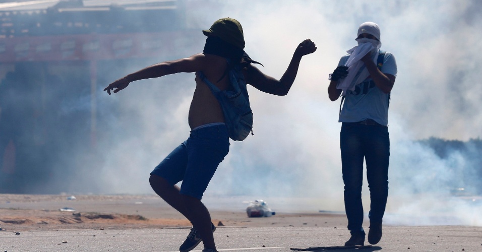 27.jun.2013 - Manifestante atira pedra em direção a policiais durante confronto em protesto que seguia rumo ao Castelão