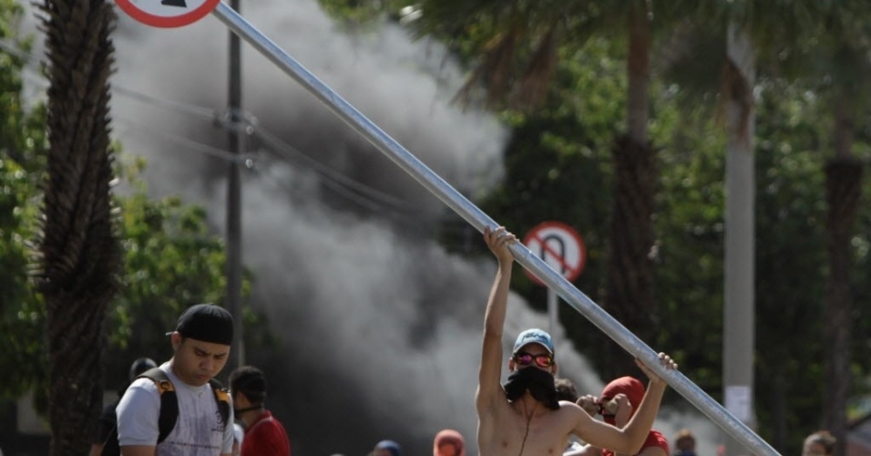27.jun.2013 - Manifestante ergue a placa que foi arrancada do chão durante protesto em Fortaleza