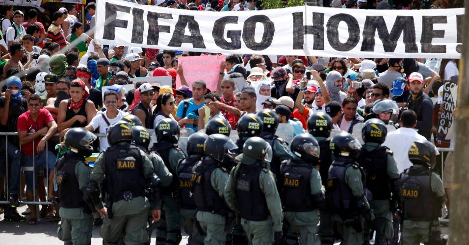 27.jun.2013 - Manifestantes carregam faixa em inglês com a frase "Vá para casa, Fifa" durante protesto em Fortaleza