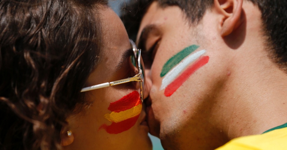 27.jun.2013 - Torcedores com as bandeiras de Espanha e Itália desenhadas no rosto se beijam no Castelão enquanto aguardam o início da semifinal da Copa das Confederações entre as duas seleções europeias