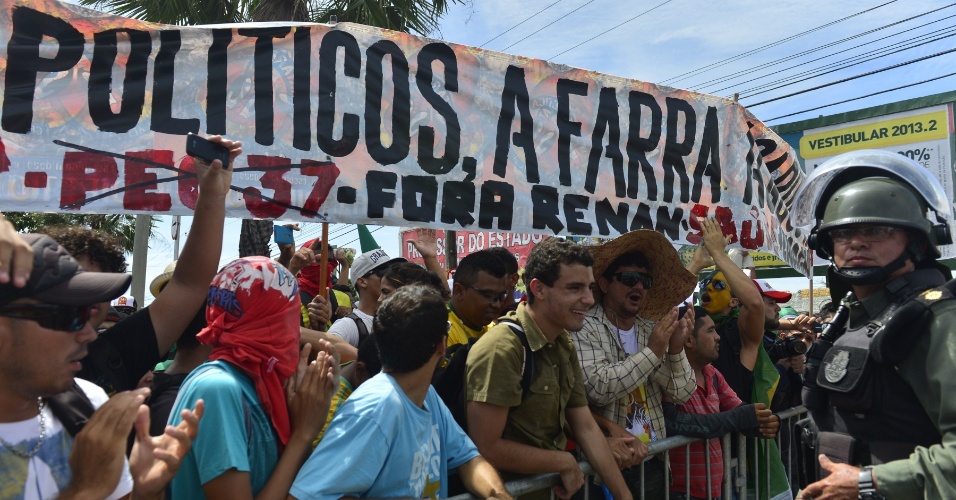 27.jun.2013 - Manifestantes exibem faixas e bandeiras contra a Copa das Confederações nas redondezas do estádio Castelão, em Fortaleza