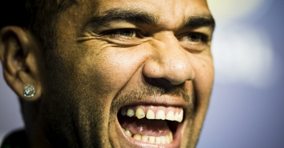 29.jun.2013 - Daniel Alves, lateral da seleção brasileira, exibe seu piercing no dente durante entrevista coletiva no Rio de Janeiro