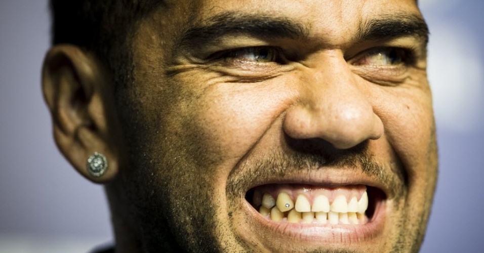29.jun.2013 - Daniel Alves, lateral da seleção brasileira, exibe seu piercing no dente durante entrevista coletiva no Rio de Janeiro