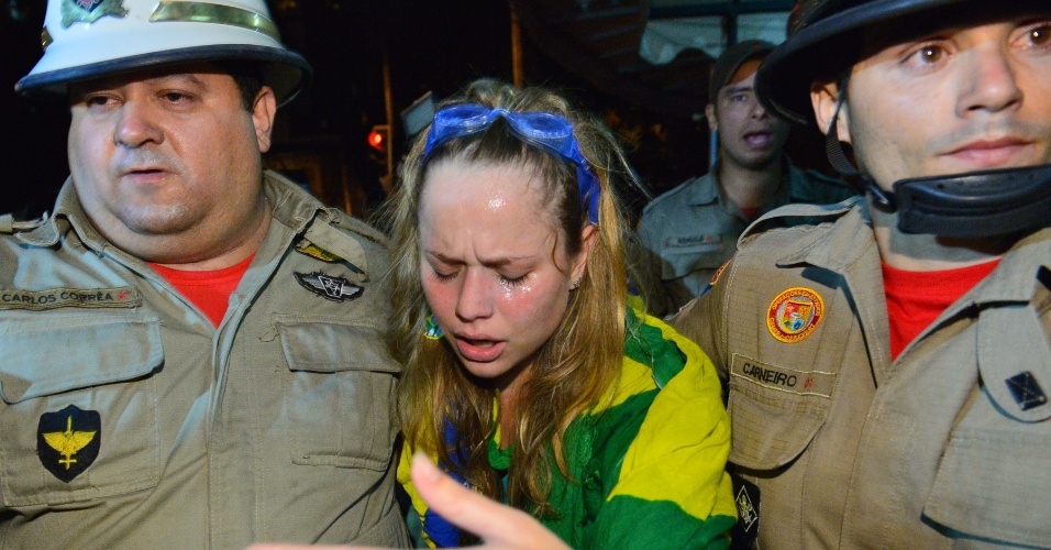 30.jun.2013 - Bombeiros amparam mulher afetada por gás lacrimogênio em protesto perto do Maracanã