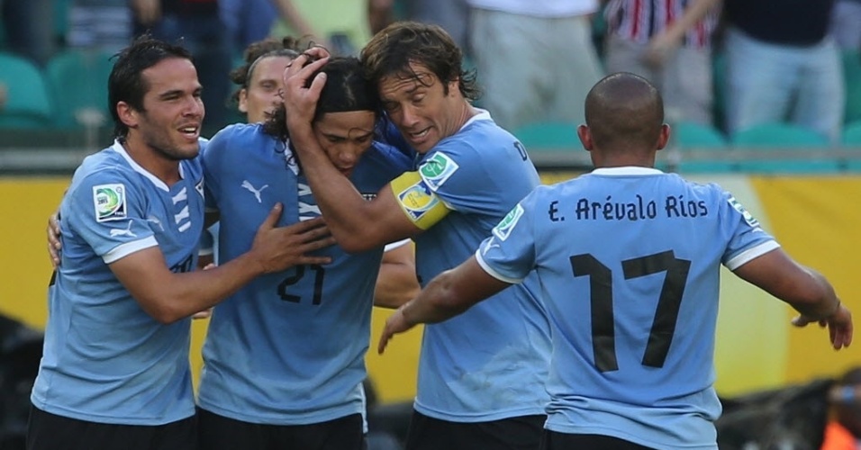30.jun.2013 - Lugano abraça Cavani, autor do gol de empate do Uruguai contra a Itália