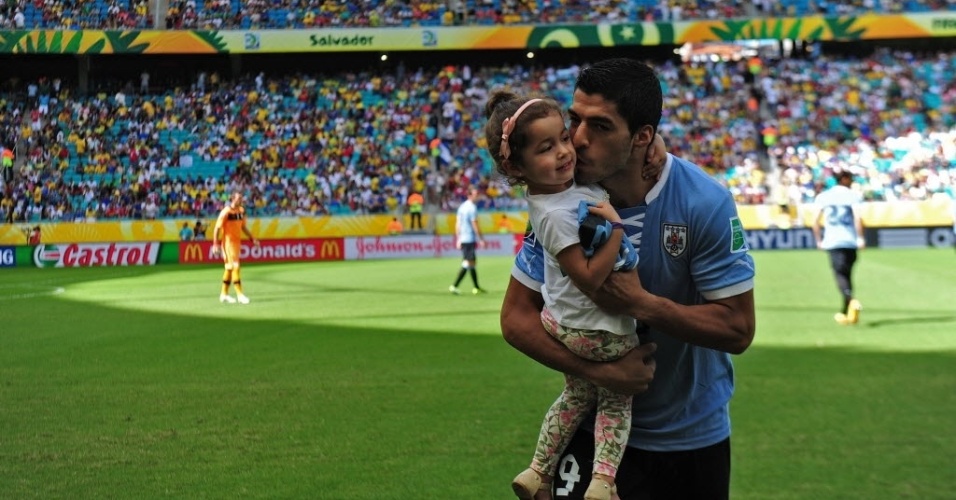 30.jun.2013 - O uruguaio Luis Suárez beija a filhinha antes do começo de Uruguai x Itália