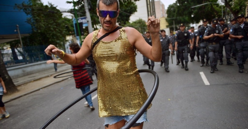Manifestante inova e rebola no bambolê vigiado por policiais próximos ao Maracanã