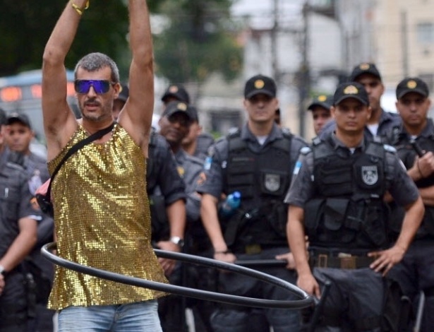Manifestante inova e rebola no bambolê vigiado por policiais próximos ao Maracanã
