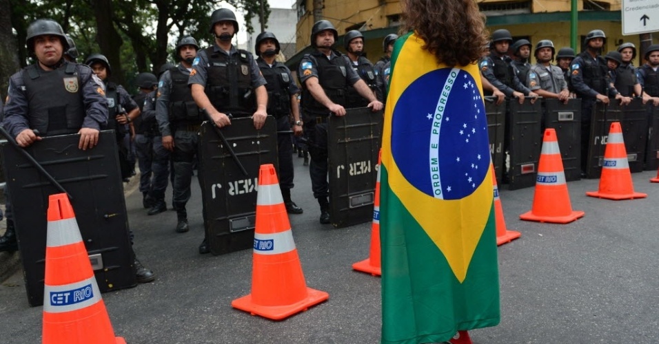 Manifestante se coloca à frente de policiais. Protesto no Rio é pacífico
