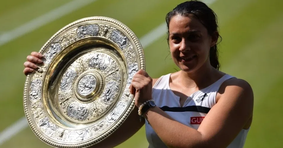 06.jul.2013 - Marion Bartoli sorri ao segurar a taça de Wimbledon, seu primeiro troféu de Grand Slam na carreira - AFP PHOTO / CARL COURT
