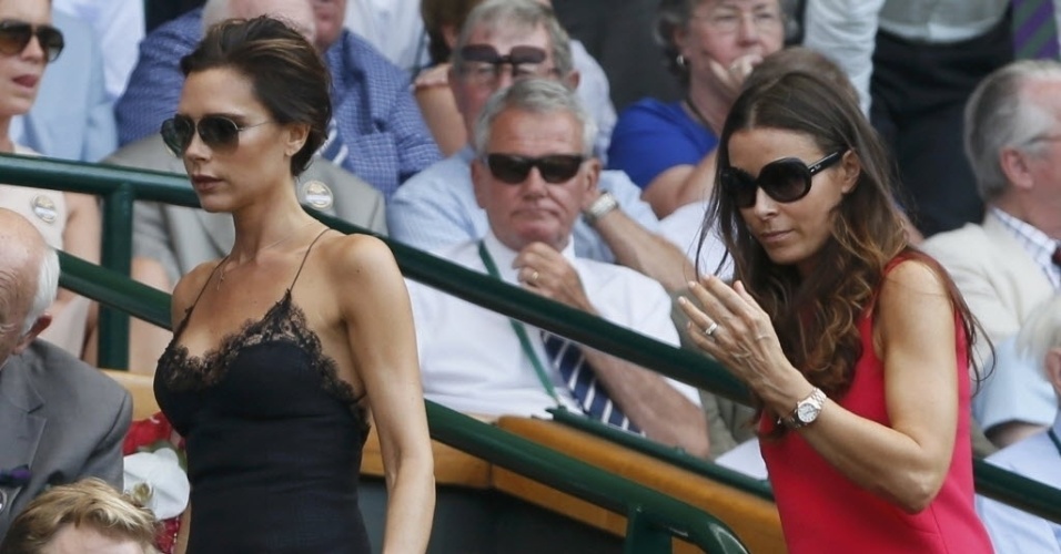 Victoria Beckham, esposa do ex-jogador de futebol David Beckham, e Tana Ramsay, esposa do famoso chef de cozinha Gordon Ramsay, caminham para os seus assentos para assistir à final de Wimbledon entre Muray e Djokovic