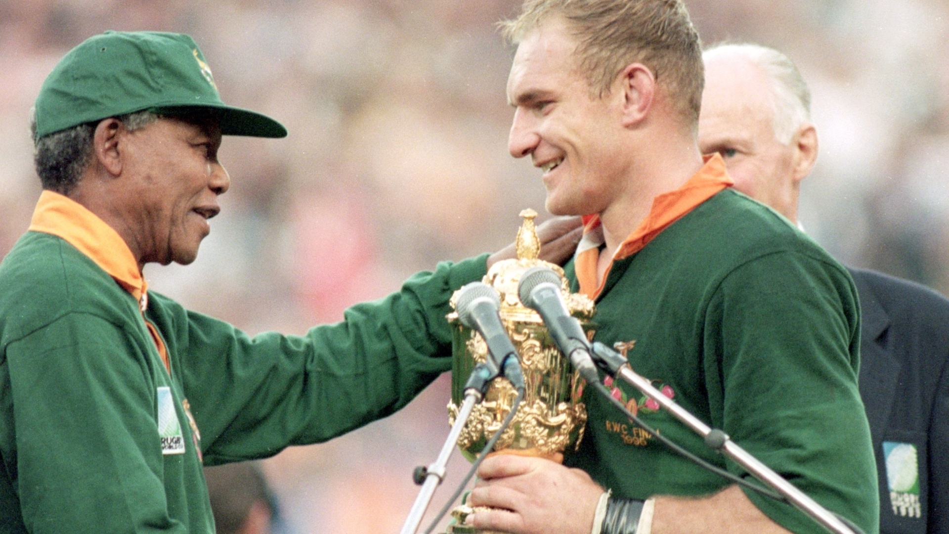 24.jun.1995 - Em momento histórico e simbólico para o fim do apartheid, Nelson Mandela entrega o troféu de campeão da Copa do Mundo de rúgbi ao capitão do time sul-africano, François Pienaar, após final contra a Nova Zelândia disputada no Ellis Park, em Johanesburgo - David Rodgers/Getty Images