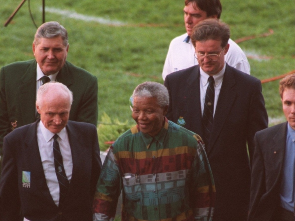 25.mai.1995 - Nelson Mandela caminha ao lado de Ewart Bell, principal executivo da Copa do Mundo de rúgbi, antes do jogo de abertura do torneio entre África do Sul e Austrália na Cidade do Cabo - Clive Mason/ALLSPORT
