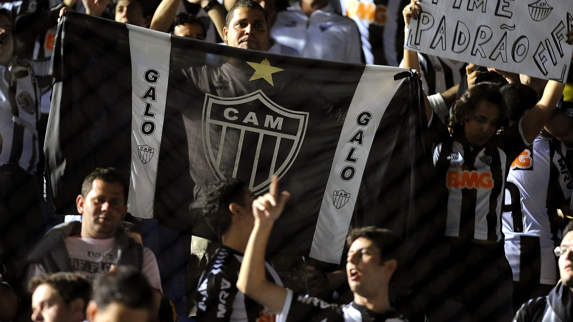 17.07.2013 - Torcedores do Atlético-MG exibem faixa "Padrão Fifa" dentro do estádio Defensores del Chaco - AFP PHOTO / Norberto Duarte