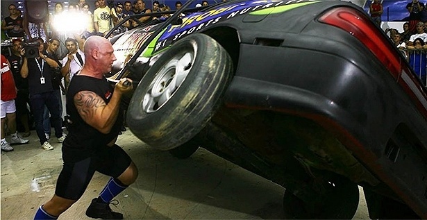 Marcos Ferrari tomba um carro adaptado durante o Brasileiro de strongman em Peruíbe, em 2012