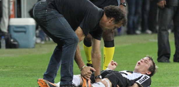 24.07.2013 - Técnico Cuca mexe na perna de Bernard, que teve que sair lesionado no final da partida - EFE/PAULO FONSECA - EFE/PAULO FONSECA