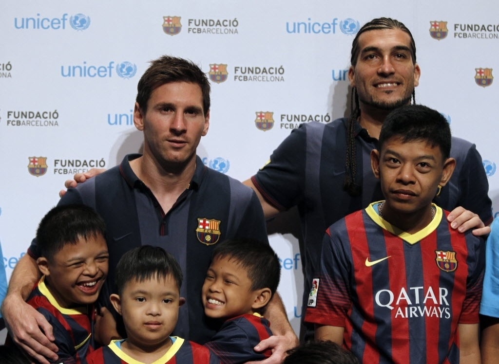Messi e José Manuel Pinto, do Barcelona, participam de ação social com crianças na Tailândia - AFP PHOTO/ Nicolas ASFOURI