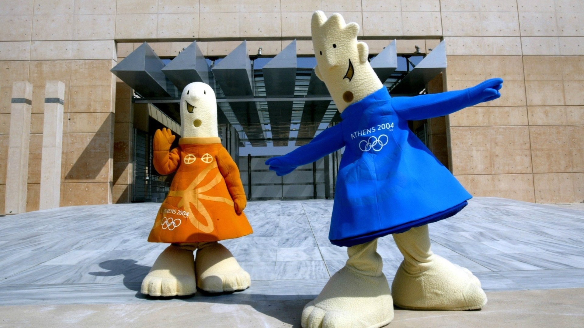 26.jul.2004 - Athena (e) e Phevos, mascotes da Olimpíada de Atenas-2004, posam em frente ao local de início da maratona