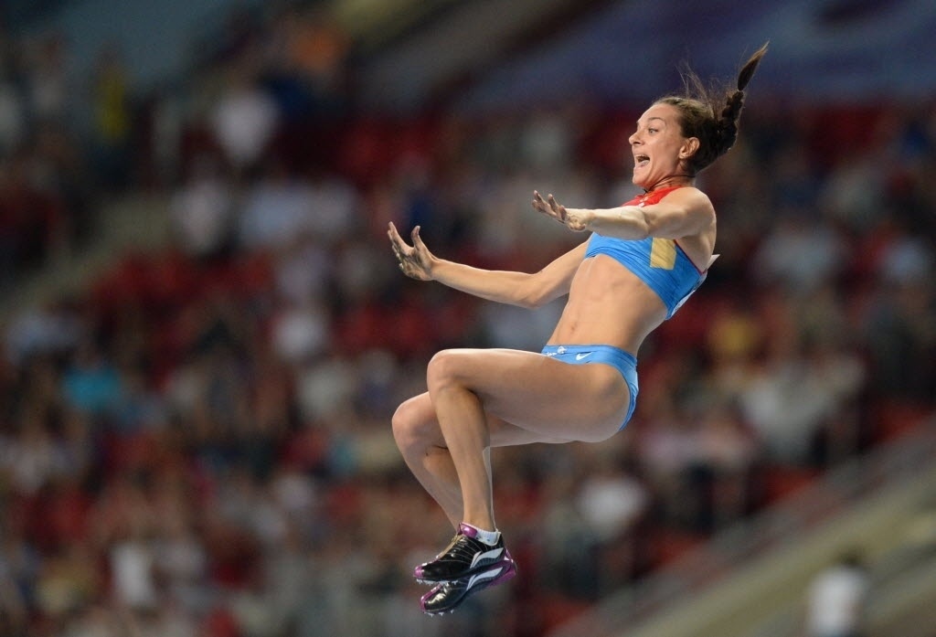 13.ago.2013 - Ainda no ar, Yelena Isinbayeva comemora seu salto de 4,89 m, que deu o ouro para a russa - AFP PHOTO / YURI KADOBNOV