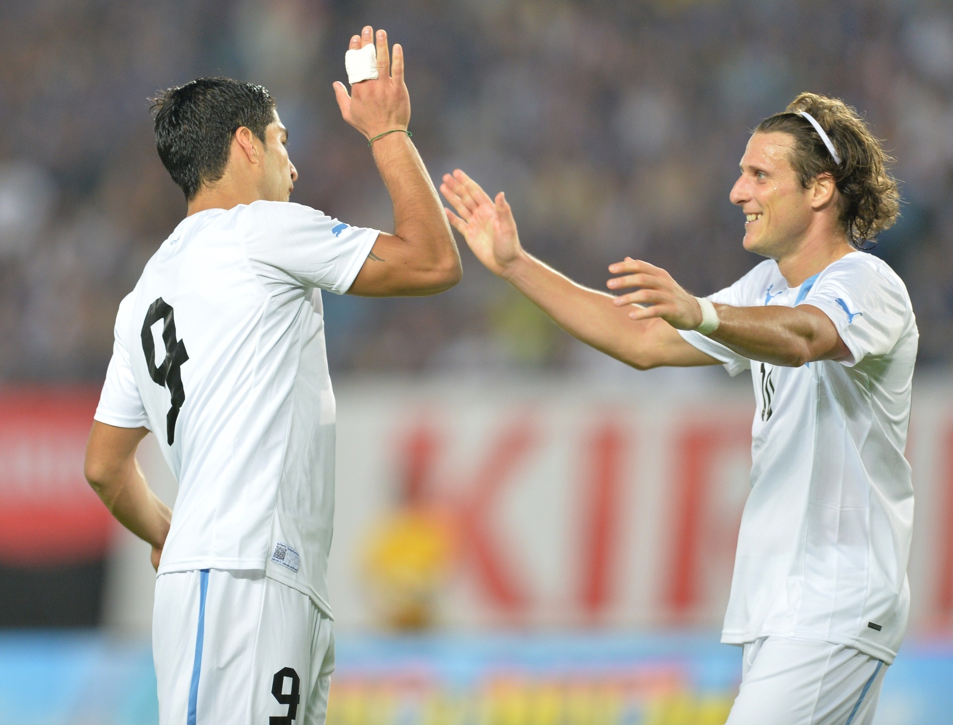 14.08.2013 - Forlán e Suarez comemoram gol do Uruguai na vitória contra o Japão em amistoso - AFP PHOTO / KAZUHIRO NOGI