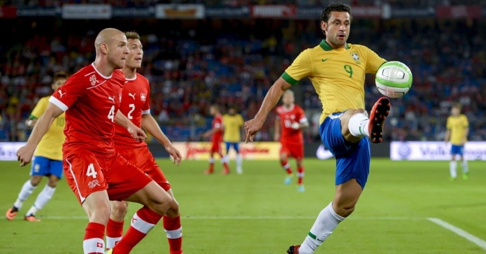 14.ago.2013 - Fred domina a bola observado por marcadores suíços durante amistoso da seleção brasileira na Basileia