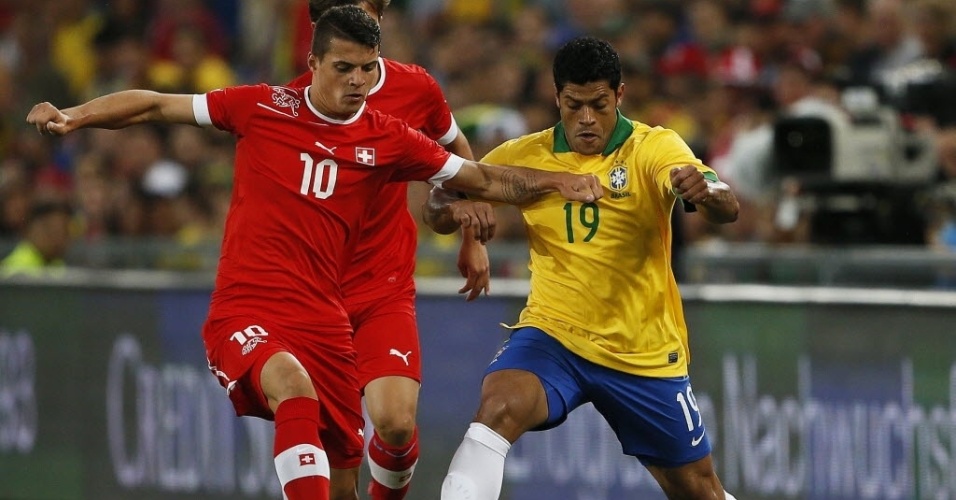 14.ago.2013 - Hulk e Granit Xhaka correm pela bola durante amistoso entre Brasil e Suíça na Basileia