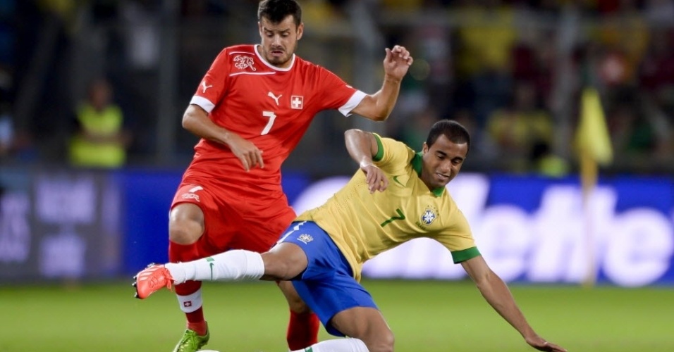 14.ago.2013 - Lucas disputa bola com Tranquillo Barnetta durante amistoso entre Brasil e Suíça