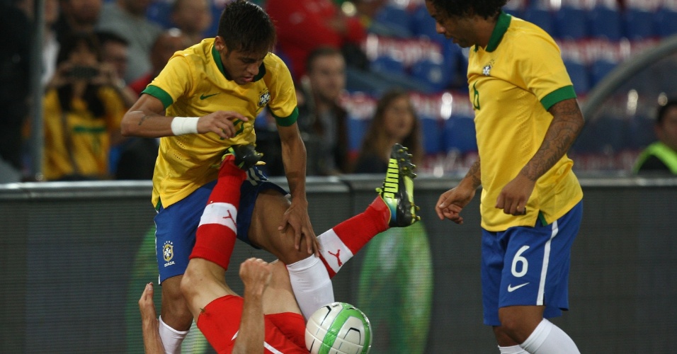 14.ago.2013 - Neymar e Marcelo se enrolam em disputa de bola com jogador suíço durante amistoso da seleção na Basileia