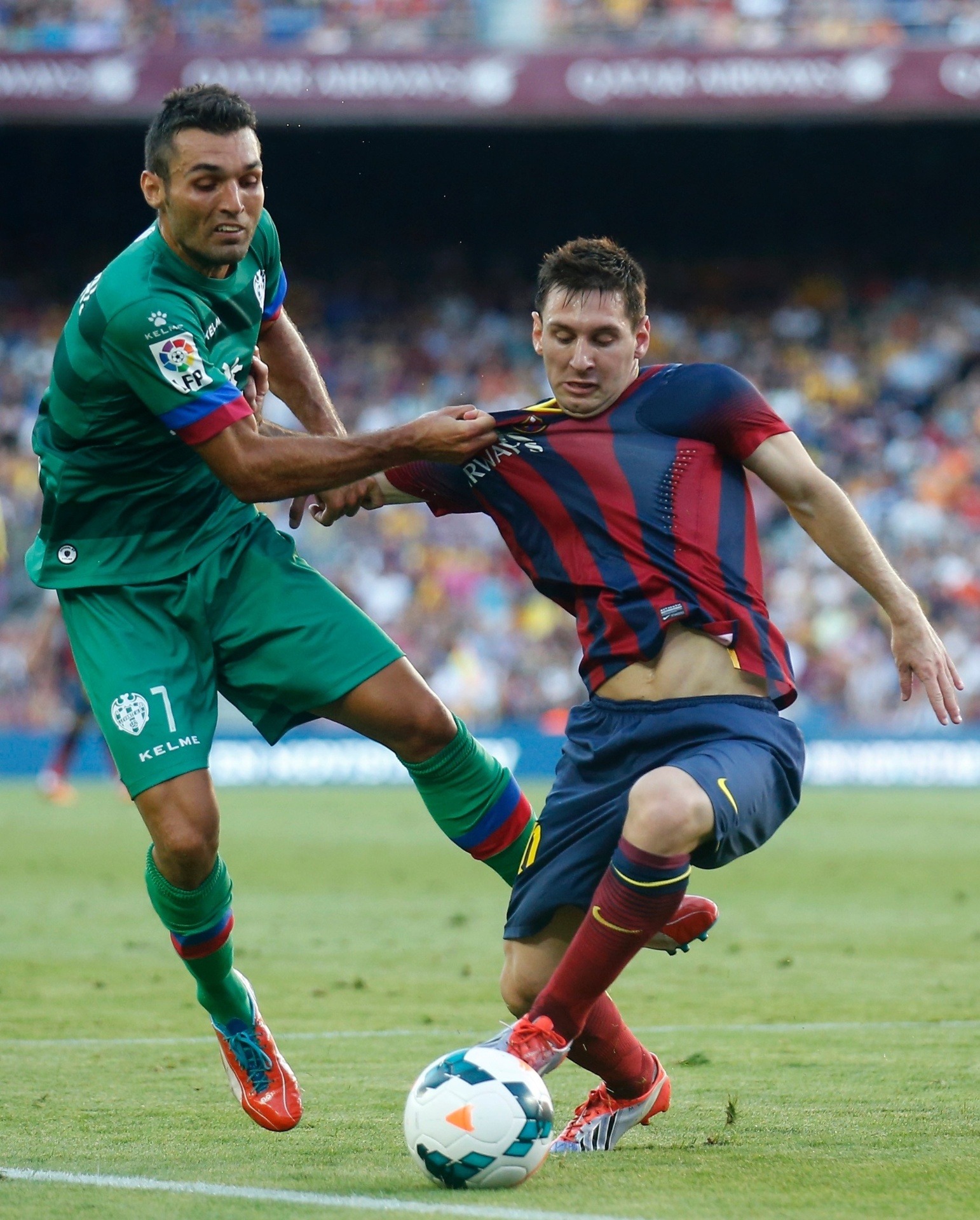 Messi é puxado por jogador do Levante durante partida do Campeonato Espanhol - REUTERS/Albert Gea