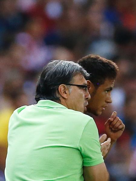 21.ago.2013 - Neymar recebe instruções do técnico Tata Martino antes de entrar no jogo contra o Atlético de Madri pela Supercopa da Espanha