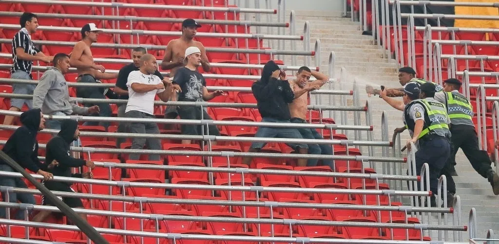 Sem camisa e com calça jeans, Leandro Silva de Oliveira é o primeiro a ser atingido por spray lançado pela polícia em confronto entre corintianos e vascaínos, em Brasília, em agosto - Sergio Lima/Folhapress