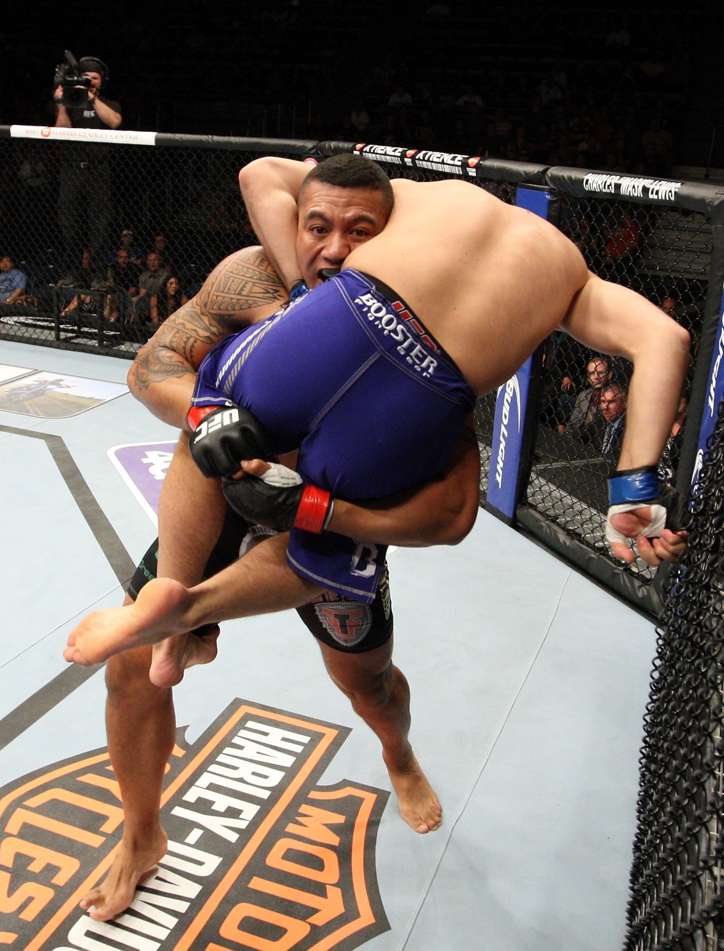 31.ago.2013 - Autraliano Soa Palelei levanta o ucraniano Nikita Krylov durante luta dos pesados no UFC 164 - Ed Mulholland/Zuffa LLC/Getty Images