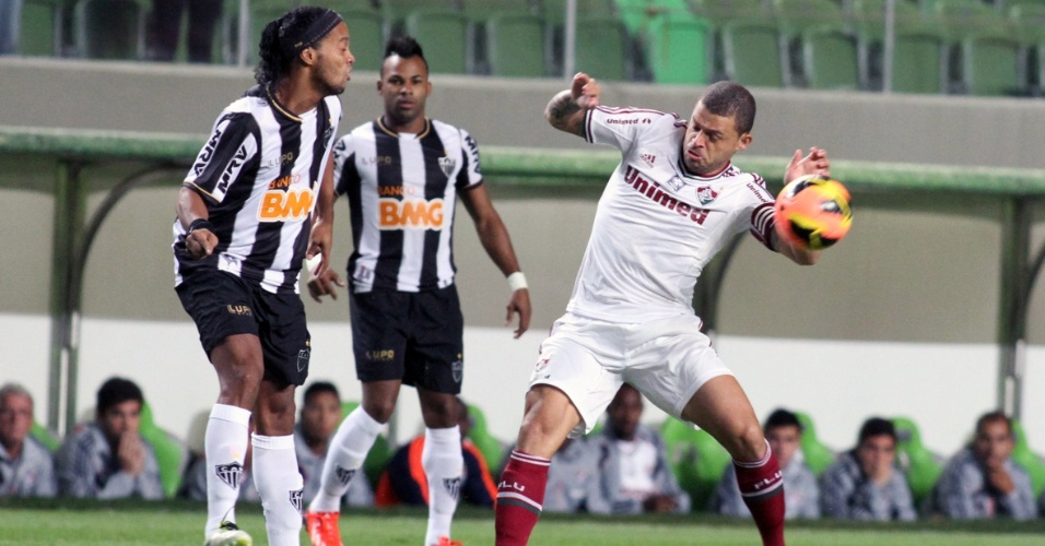 04.set.2013 - Observado por Fernandinho, Ronaldinho tenta o passe em partida contra o Fluminense