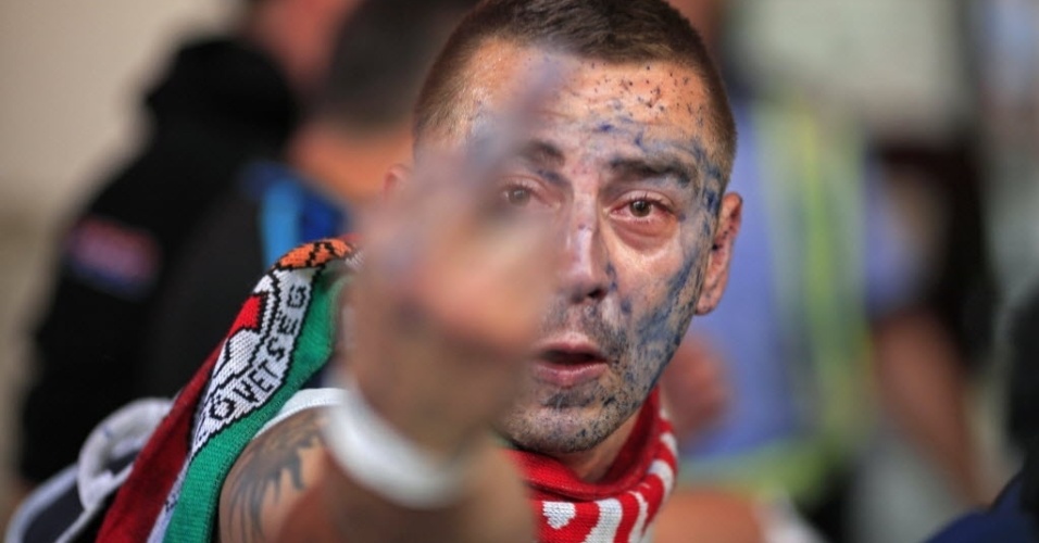 6.set.2013 - Torcedor húngaro faz gesto obsceno ao ser fotografado durante briga com policiais romenos antes de jogo das Eliminatórias